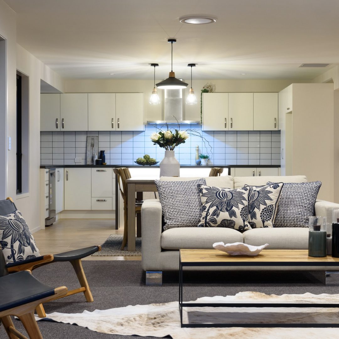 New open plan kitchen & living area with modern lighting features, Deluxe Homes.