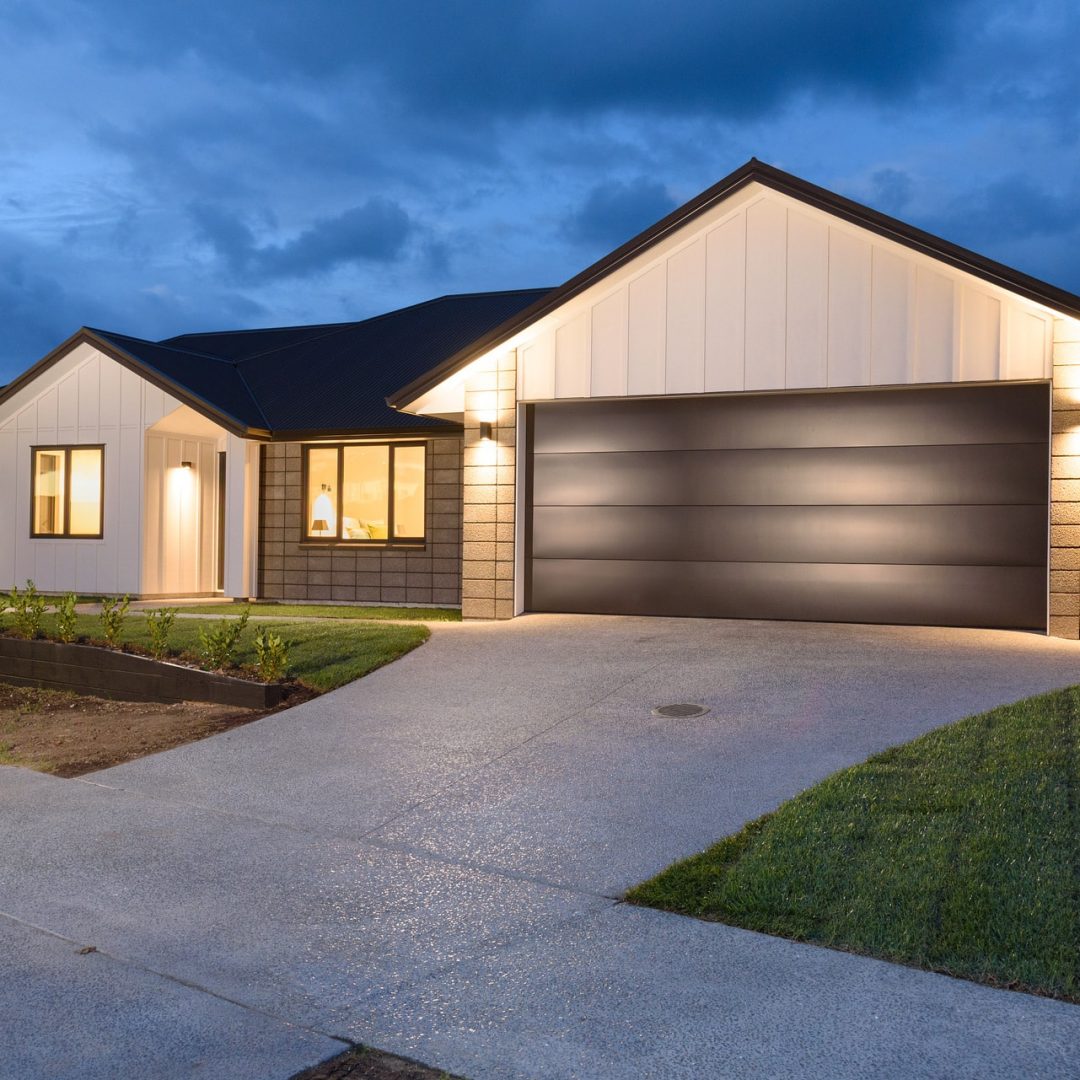 New home with modern garage doors by Deluxe Homes.